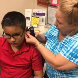 nurse examining inside a child's ear