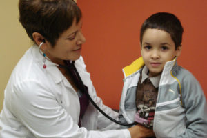 pediatrician listening to heartbeat of young boy