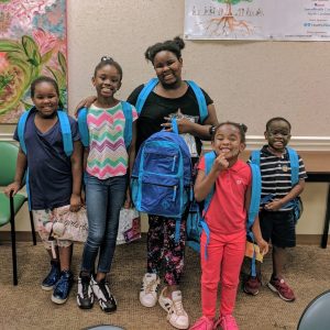 group of young children wearing backpacks at Children's Health Day event