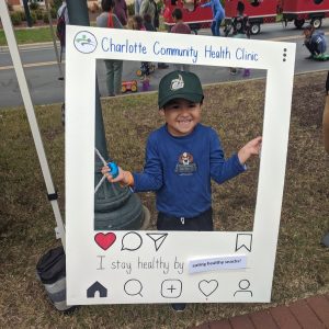 young boy outside holding oversized picture frame